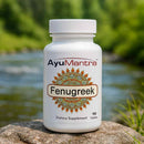 AyuMantra Fenugreek Tablets bottle on a rock by a river, 90-tablet dietary supplement label visible.
