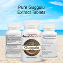 Pure Guggulu Extract Tablets set showing front, supplement facts and back label on beach background.