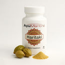 Pure Haritaki Tablets extract set with front, supplement facts and usage labels against mountain background.